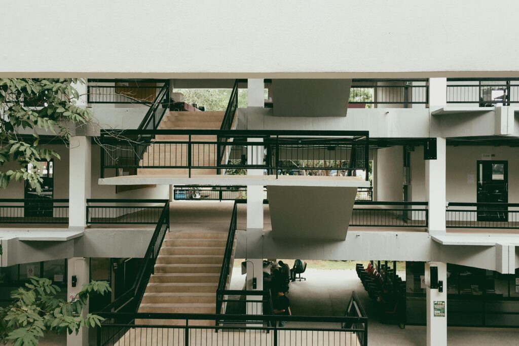 Spacious modern building interior featuring a multi-level open staircase with black metal railings.